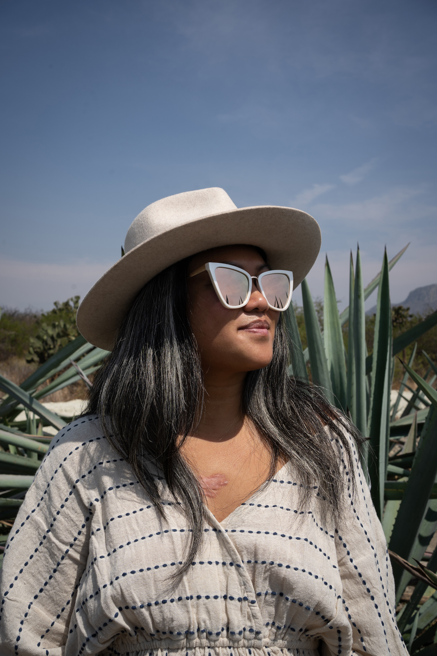 http://schimiggy.com/wp-content/uploads/2021/05/Agave-Fields-Mezcal-Tour-Gigi-Pip-Zephyr-Hat-World-Market-Dress-Quay-Sunglasses.jpg